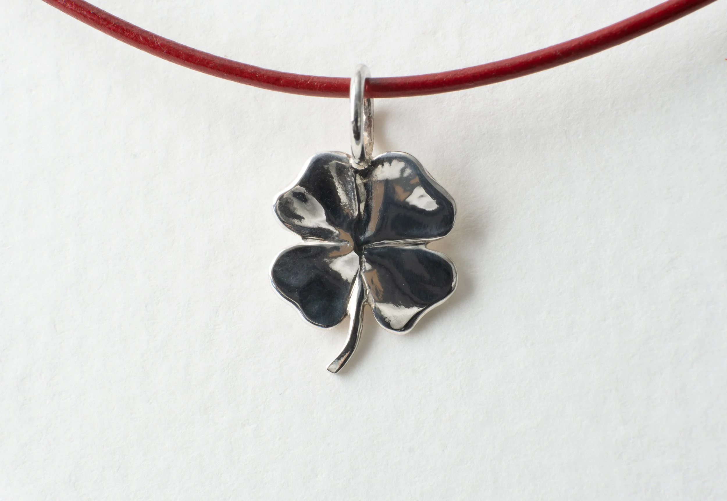 silver shamrock large on red cord
