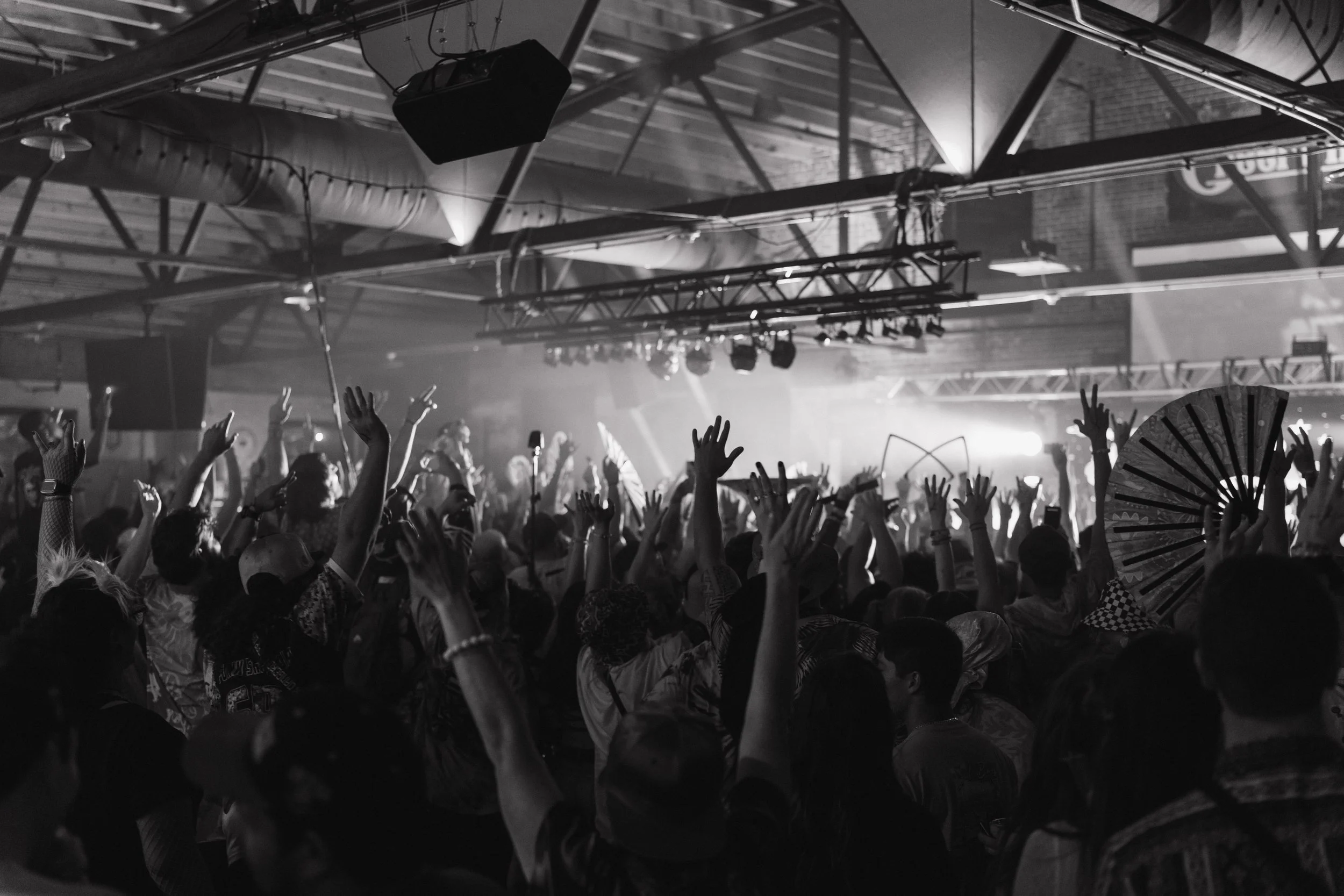 Crowd at a concert raising hands indoors, black and white photo. Wilmington. NC. Headliner. Collab. Main feature. Feature. Success. Music. Live. DJ. Violin. Show. Performance. 