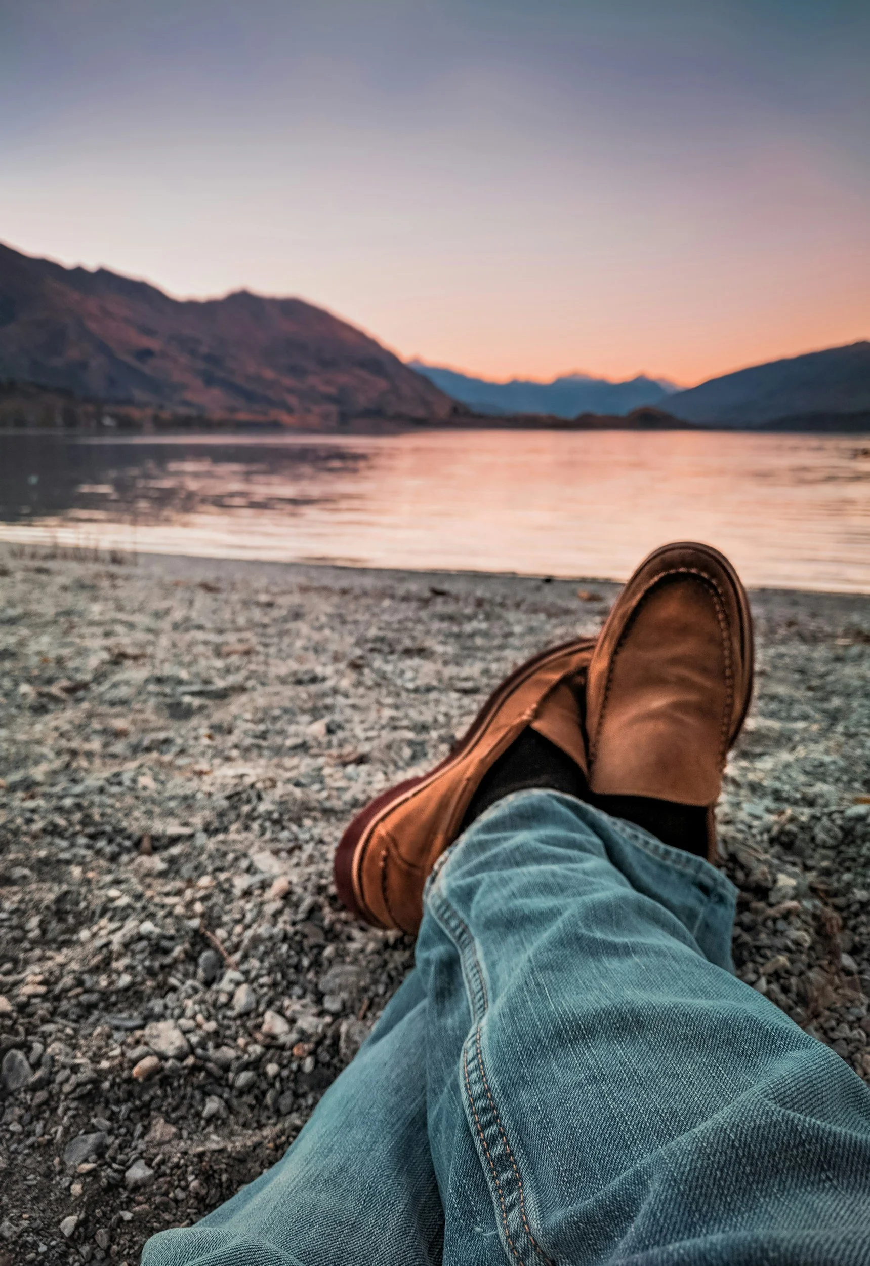 sitting on lake edge with legs extended and viewing the water