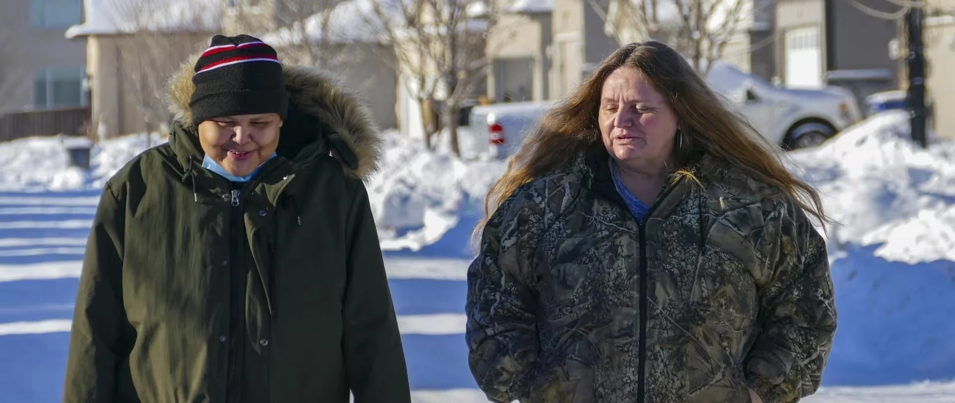 Rosetta Bignell (left) and her clinical case manager, Colleen Slater (right) from Life's Journey on a walk in the winter. Snow, trees, and houses are in the background..