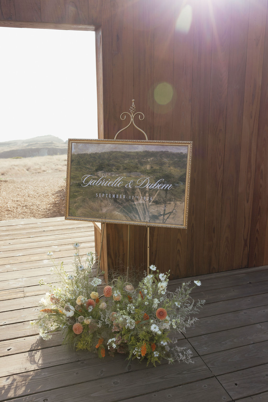 Gabrielle and Dubem wedding sign with wild, natural ground flower arrangement at Sea Ranch