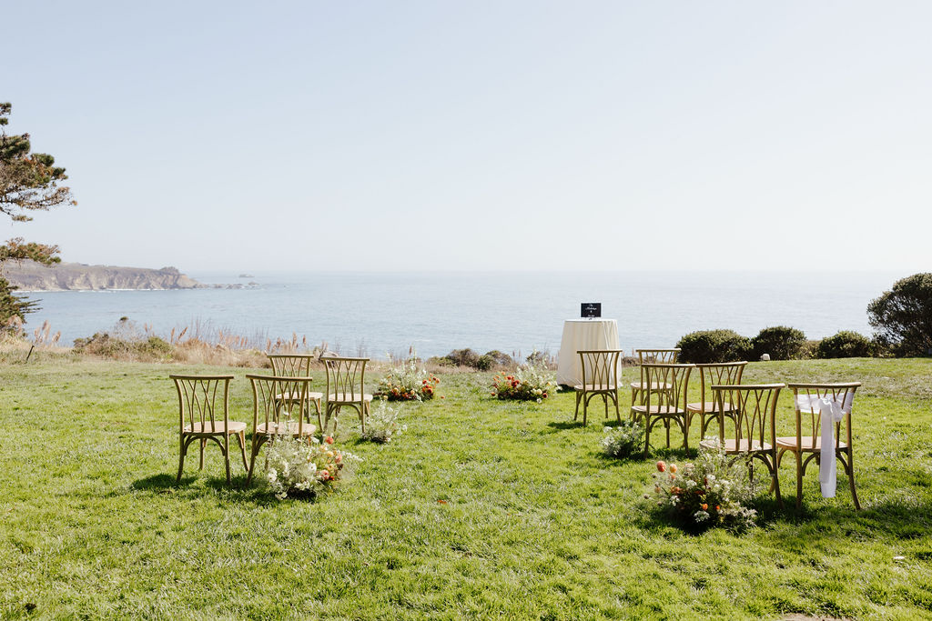 Low organic aisle runner floral arrangements for a coastal outdoor wedding ceremony at Sea Ranch