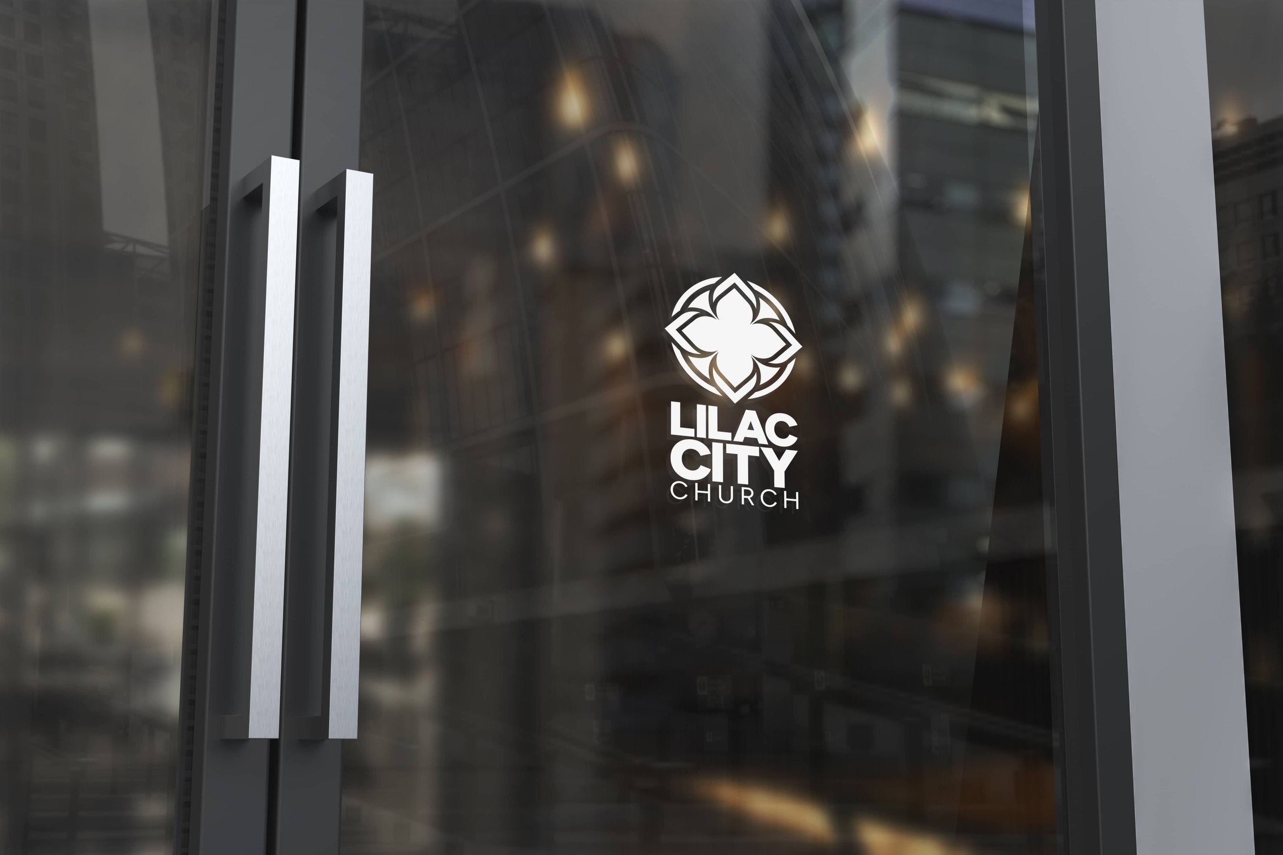 Glass door with Lilac City Church logo and name, featuring a white floral design and silver door handles