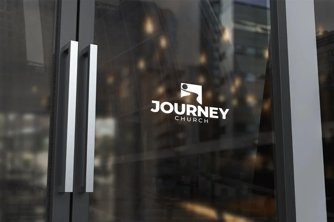 Glass door with the logo and name of Journey Church, featuring a stylized figure and text.