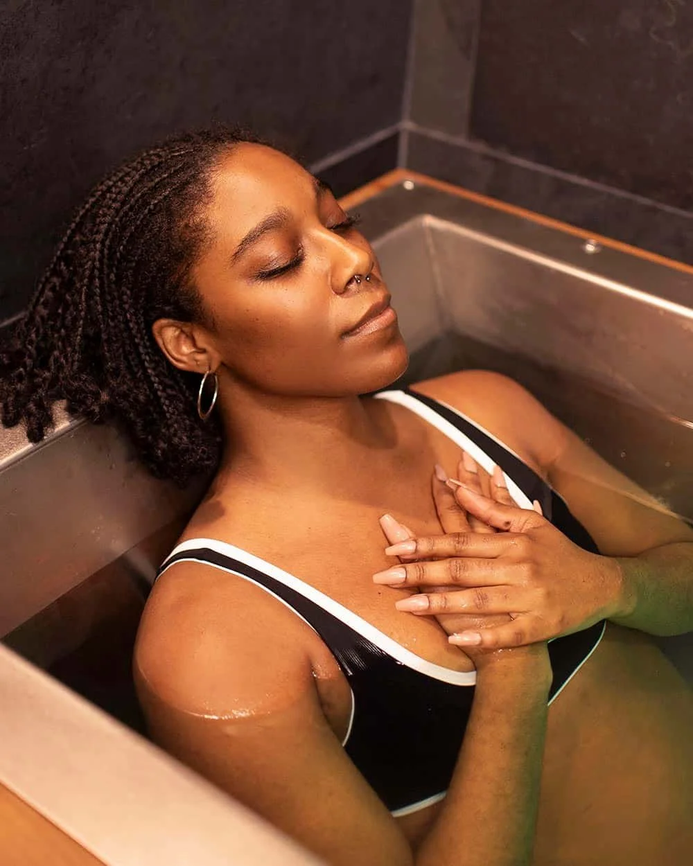 Black women in cold plunge as part of her contrast therapy