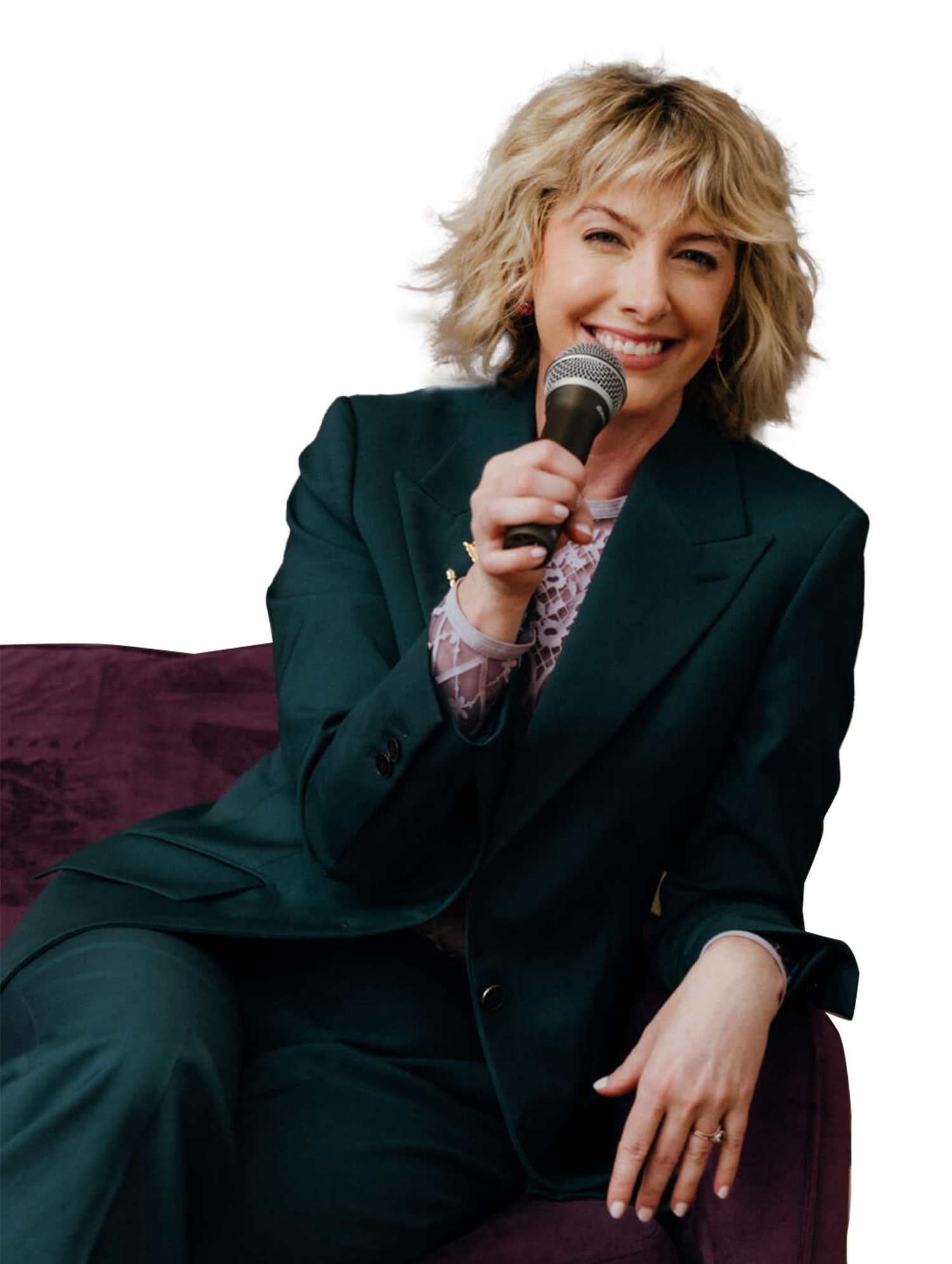 Natalie poses with a microphone in a green pantsuit