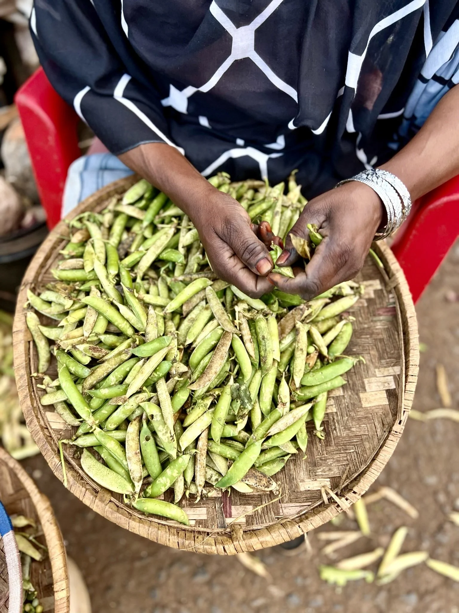 Woman with colorful produce in local Ugandan market