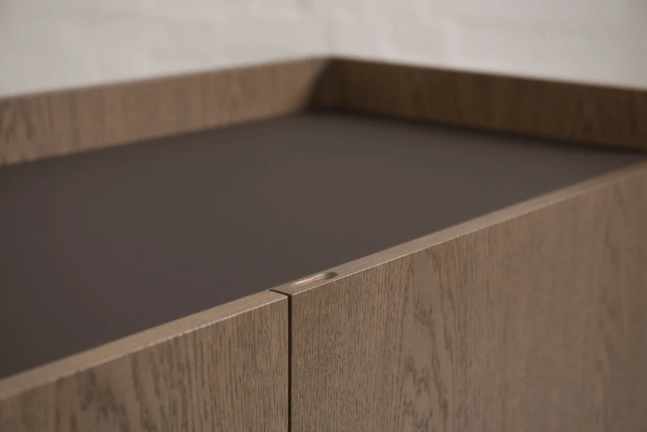 This bespoke credenza was produced in European oak veneer and laminate, set on powder-coated tubular steel legs with a matching up stand.

The secret to the perfect finish? Keeping it in-house. Our talented sprayer matched the stain perfectly to a co
