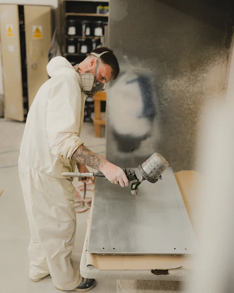 Spraying a body panel during a Land Rover Defender rebuild
