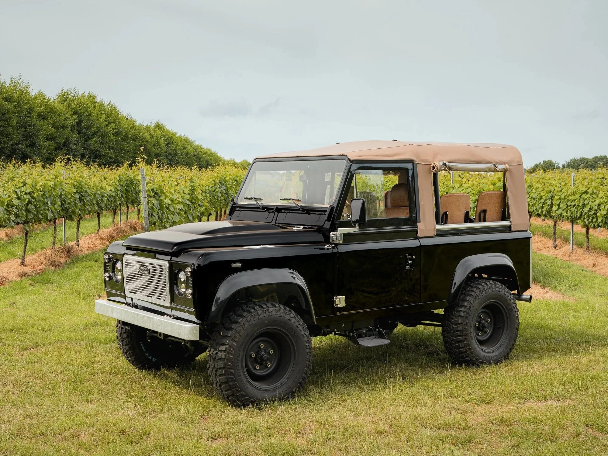 Java Black Shoreline Defender 90 with tan soft top parked in a vineyard