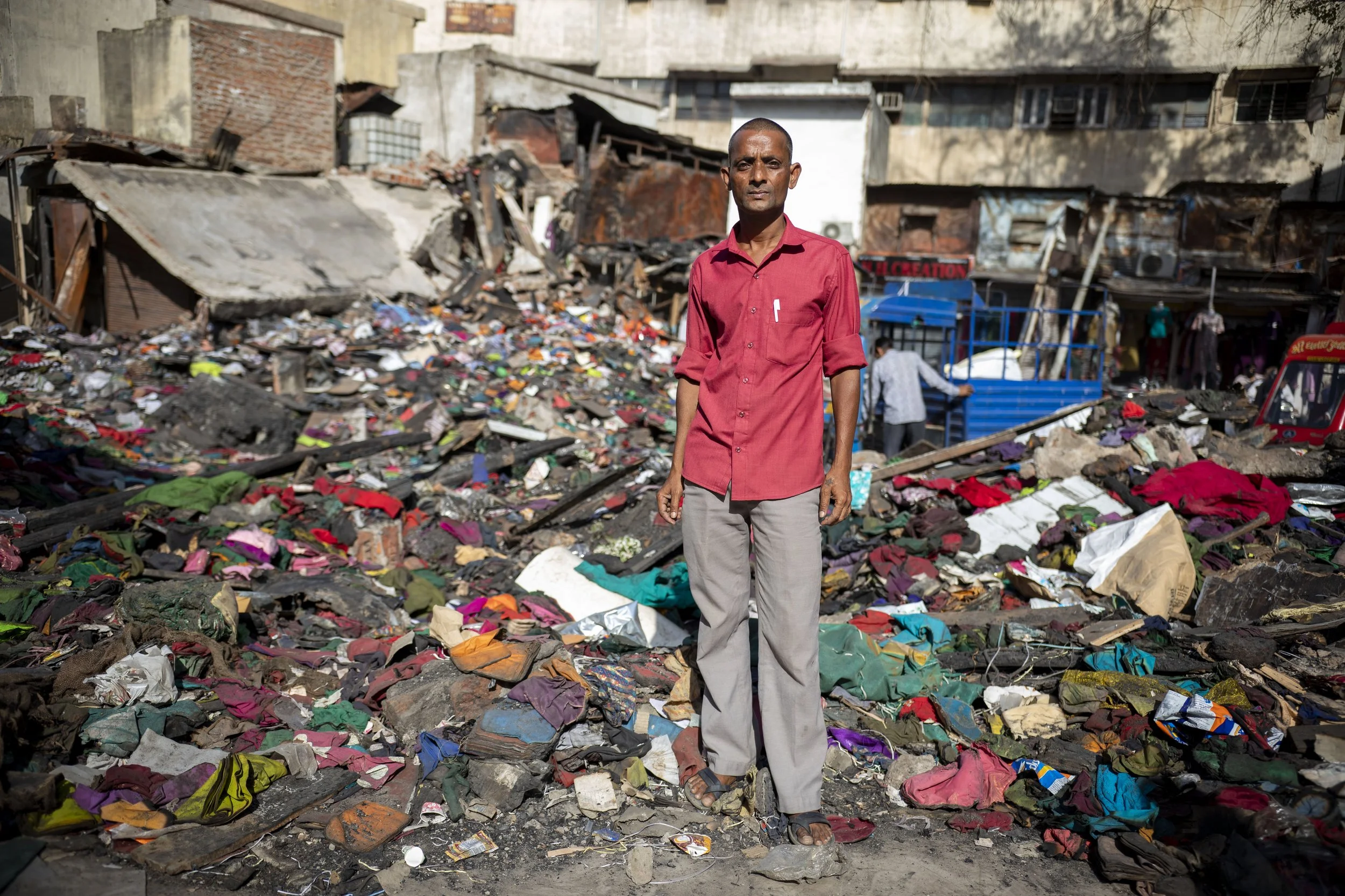 Ahmedabad, India: March 28, 2026: A man stands in front of the textile factory where he once worked, days after it was destroyed in an electrical fire the previous week.