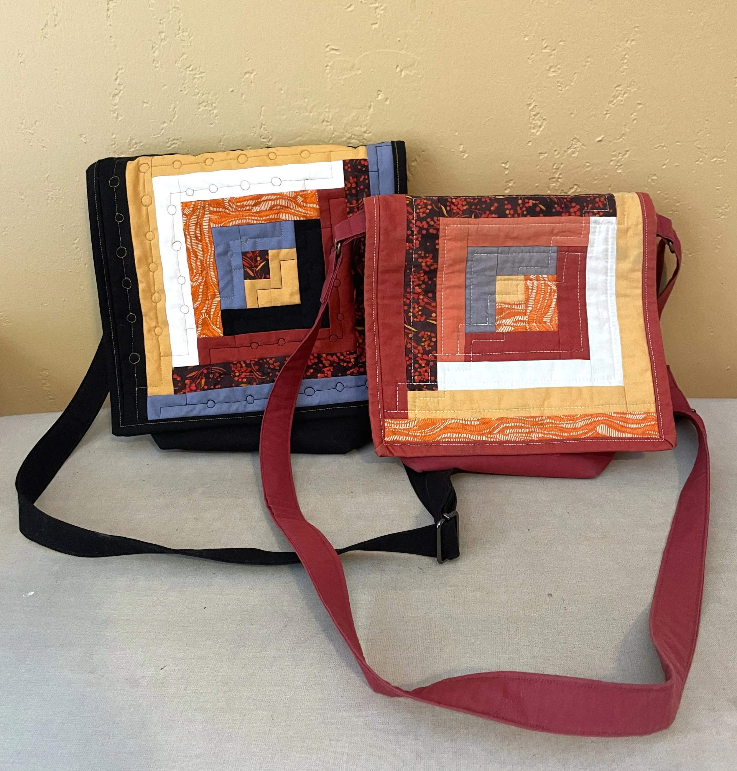 Two purses with log cabin blocks on the front.