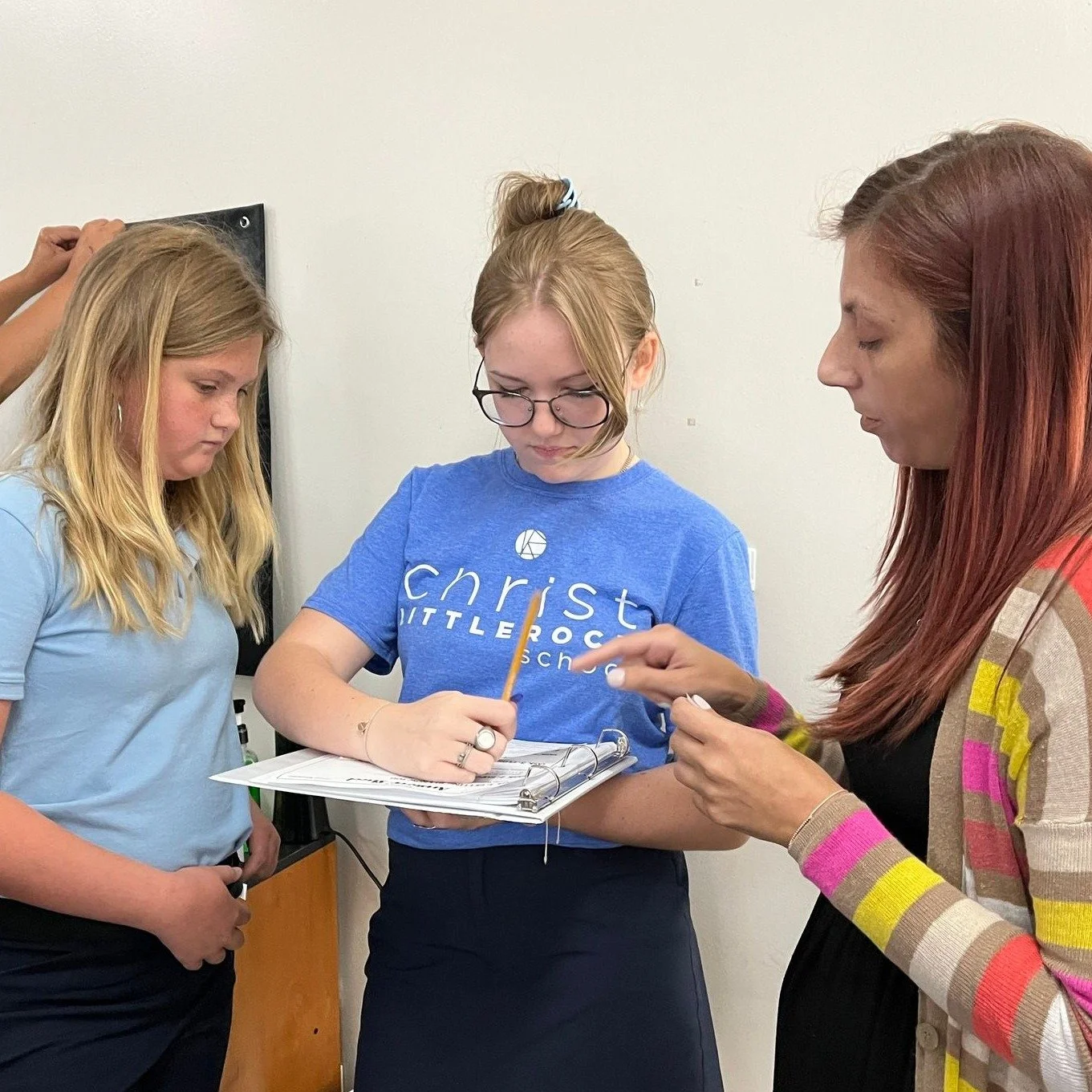 Teacher with Students Reviewing Work