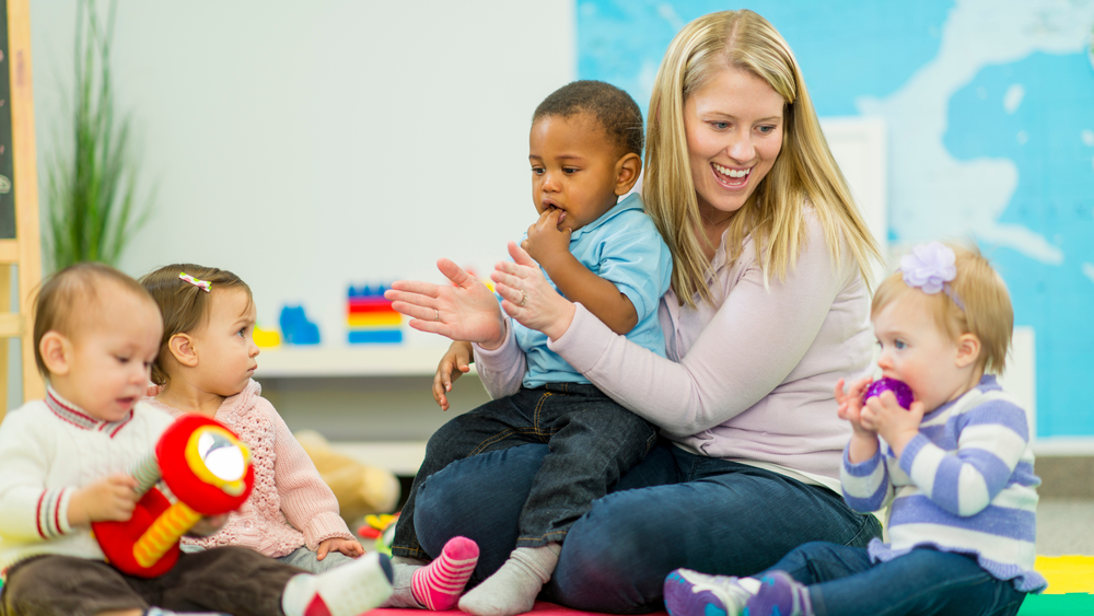 Daycare teacher caring for young children in a supportive early learning environment at Christ Little Rock School.