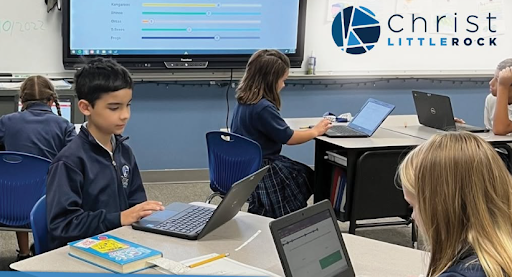 Students using laptops in a classroom at Christ Little Rock School