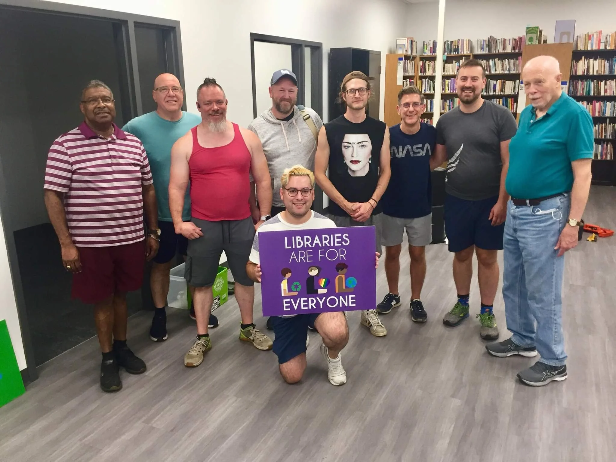 Library volunteers with a "libraries are for everyone" sign