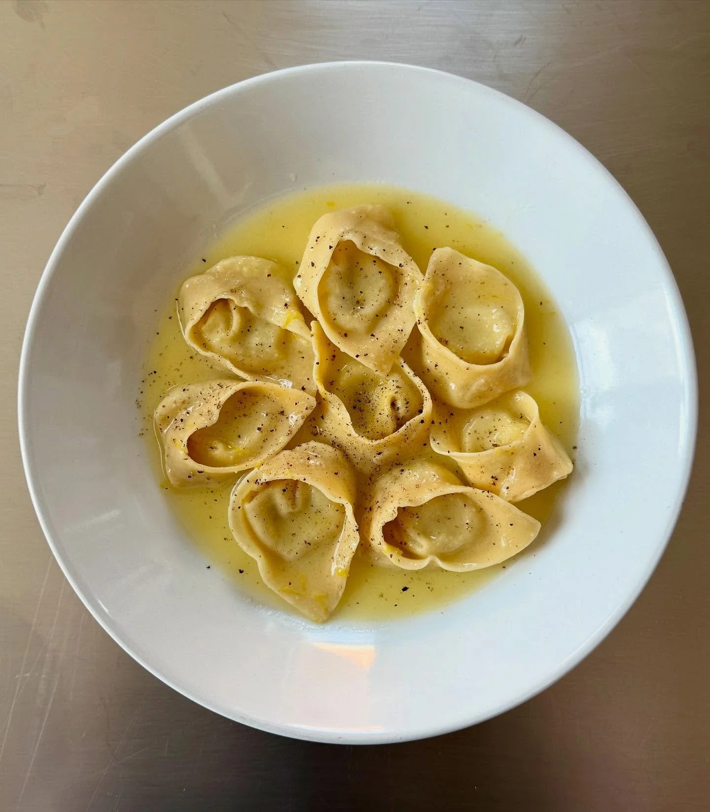 Handcrafted tortelloni filled with a creamy blend of fresh corn, ricotta, and mascarpone, with a hint of roasted shishito peppers. We cut the kernels off the cob, juice them, and cook the corn milk to capture its natural sweetness and starch, then fo