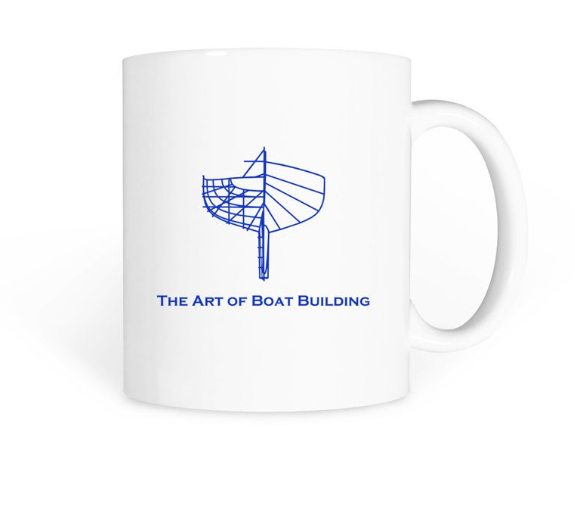 White mug with a blue outline of a boat and the text "The Art of Boat Building" below the graphic.