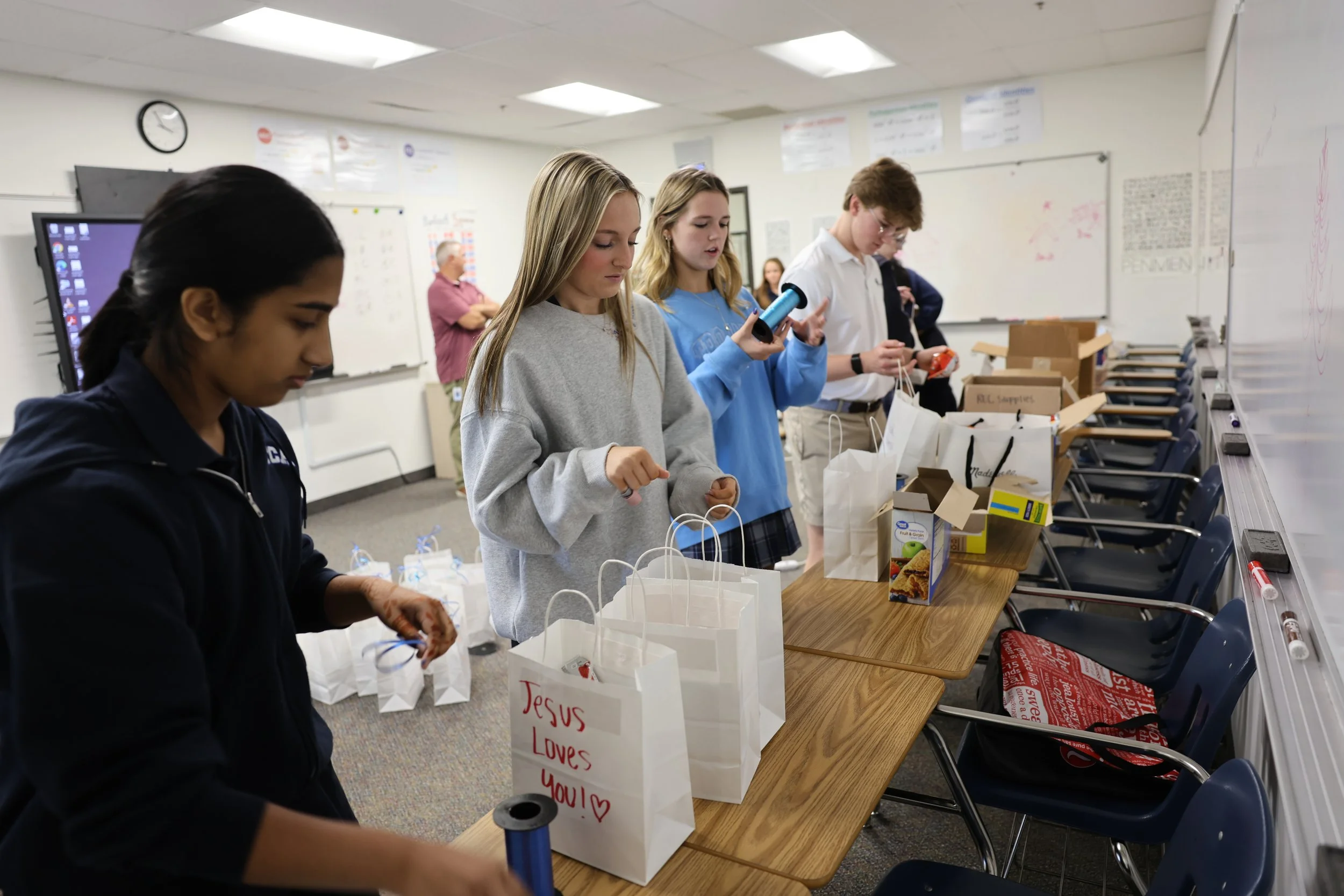Trinity Christian Academy students packing care kits with water, snacks and hygiene items for people experiencing homelessness in North Texas