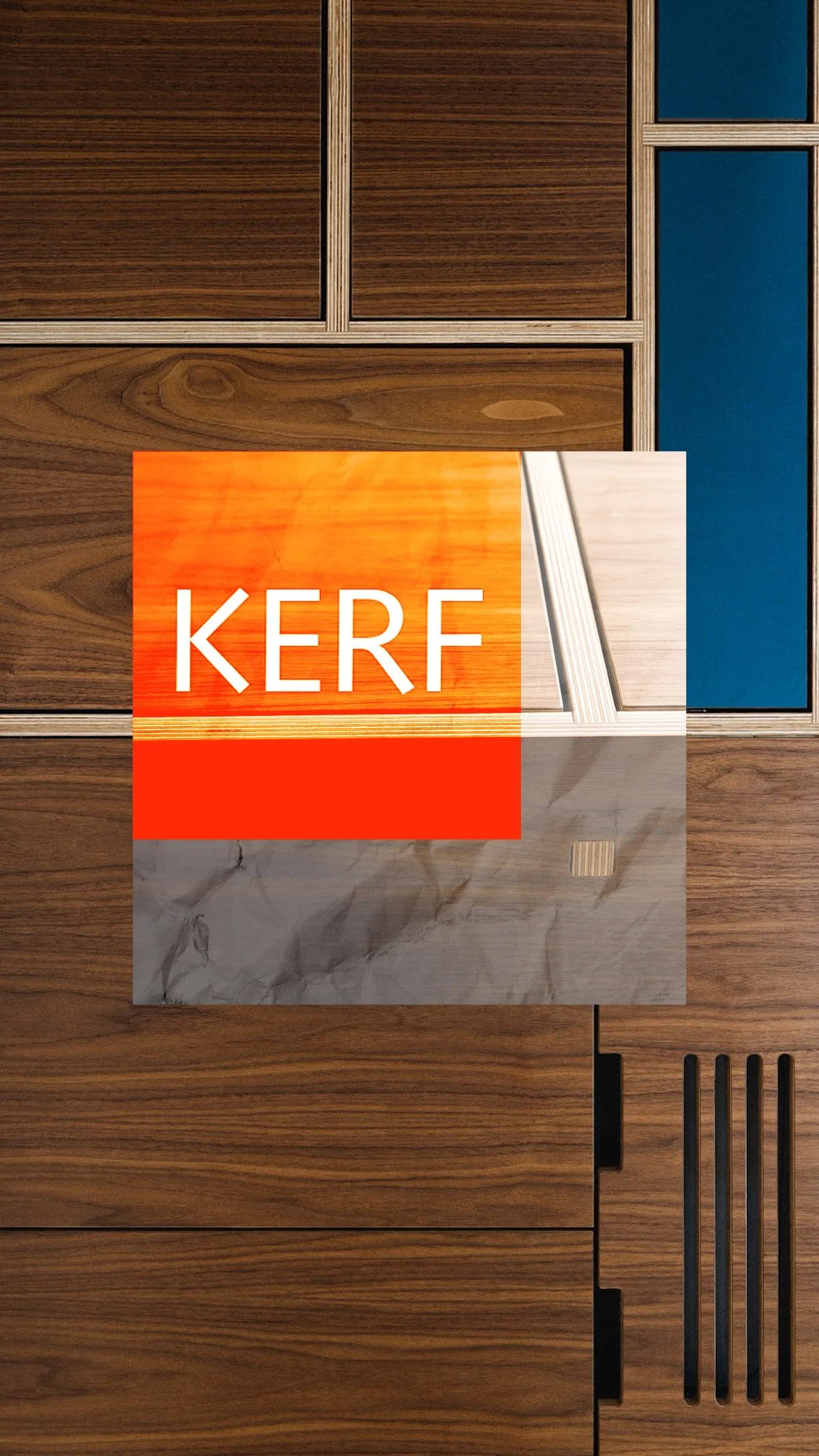Close-up of wooden cabinet doors with a business card displaying the logo 'KERF' placed on the surface.