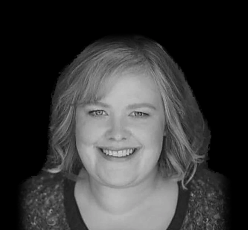 Black and white portrait of a woman smiling with short hair.