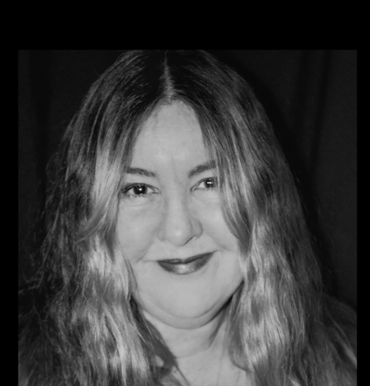 Black and white portrait of a person smiling with long hair.
