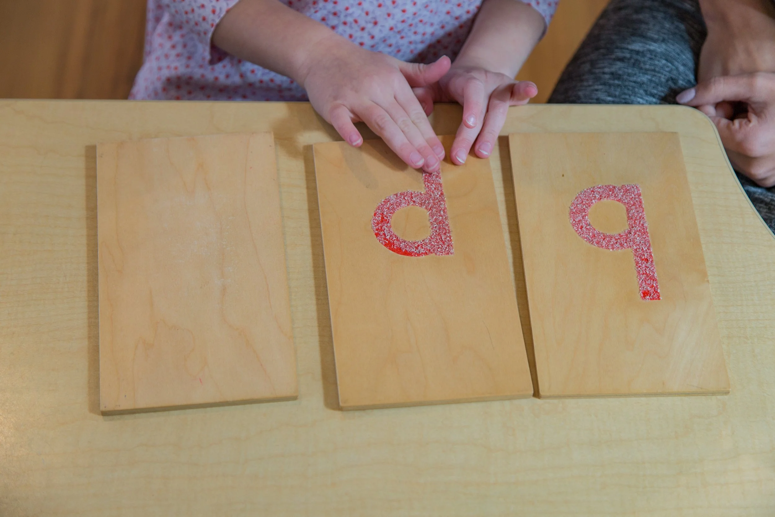 A child completes a lesson using the sandpaper letters.
