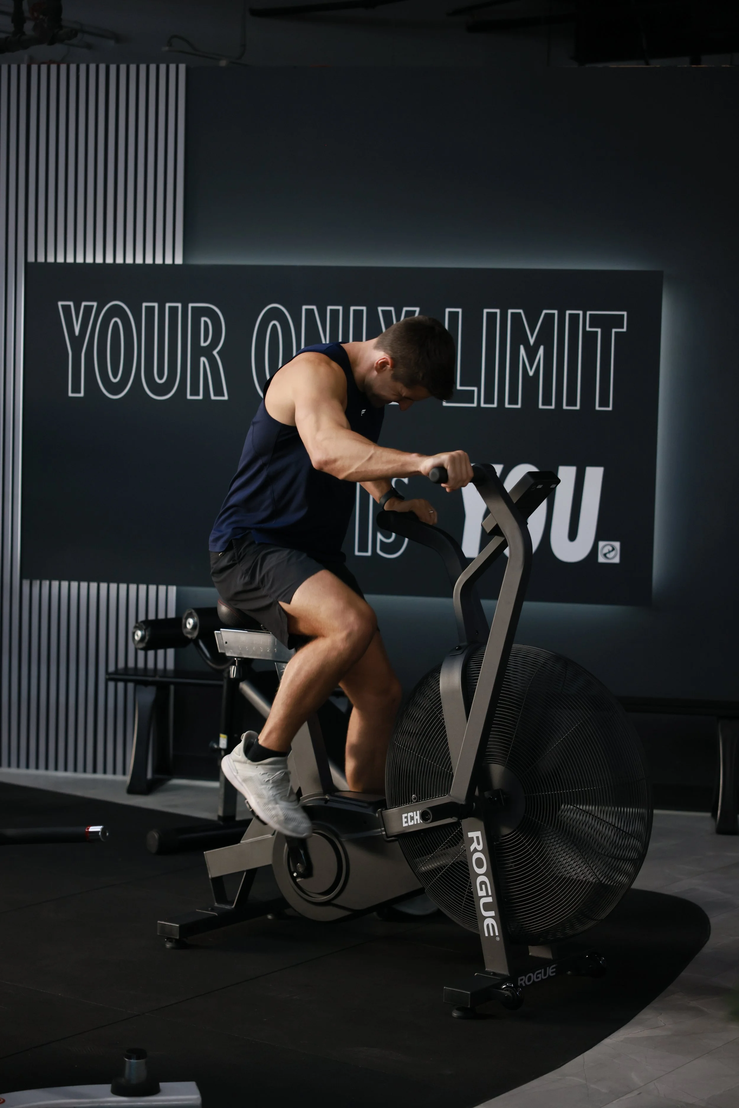 Fitness studio member exercising on Rogue Echo bike at Paradigm gym in Dallas.