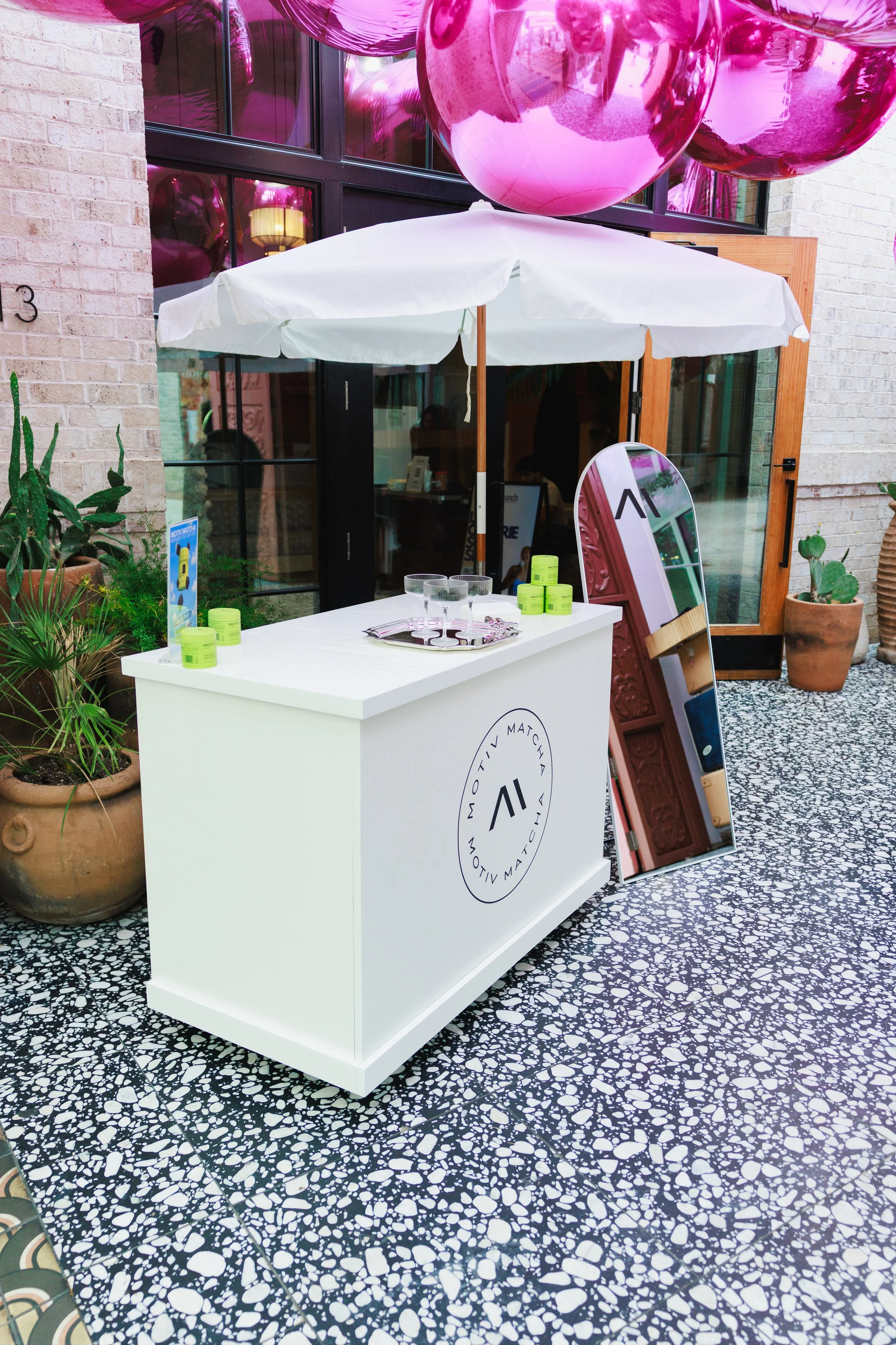 Branded custom cart, umbrella and selfie mirror product sampling activation setup for MOTIV MATCHA energy gummies.