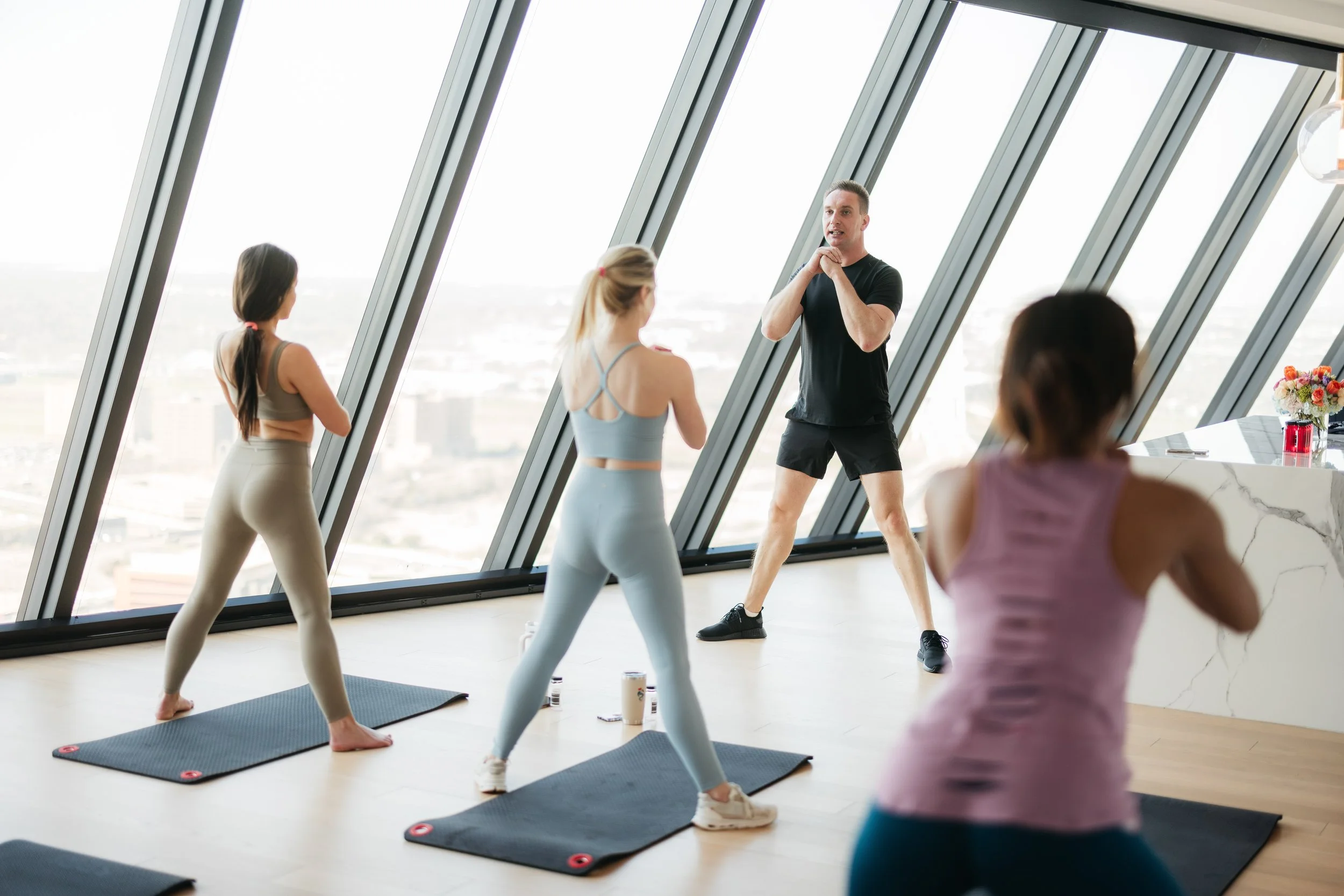 Fitness instructor teaching Dallas influencers an exercise at an experiential marketing event for AMLI Fountain Place.