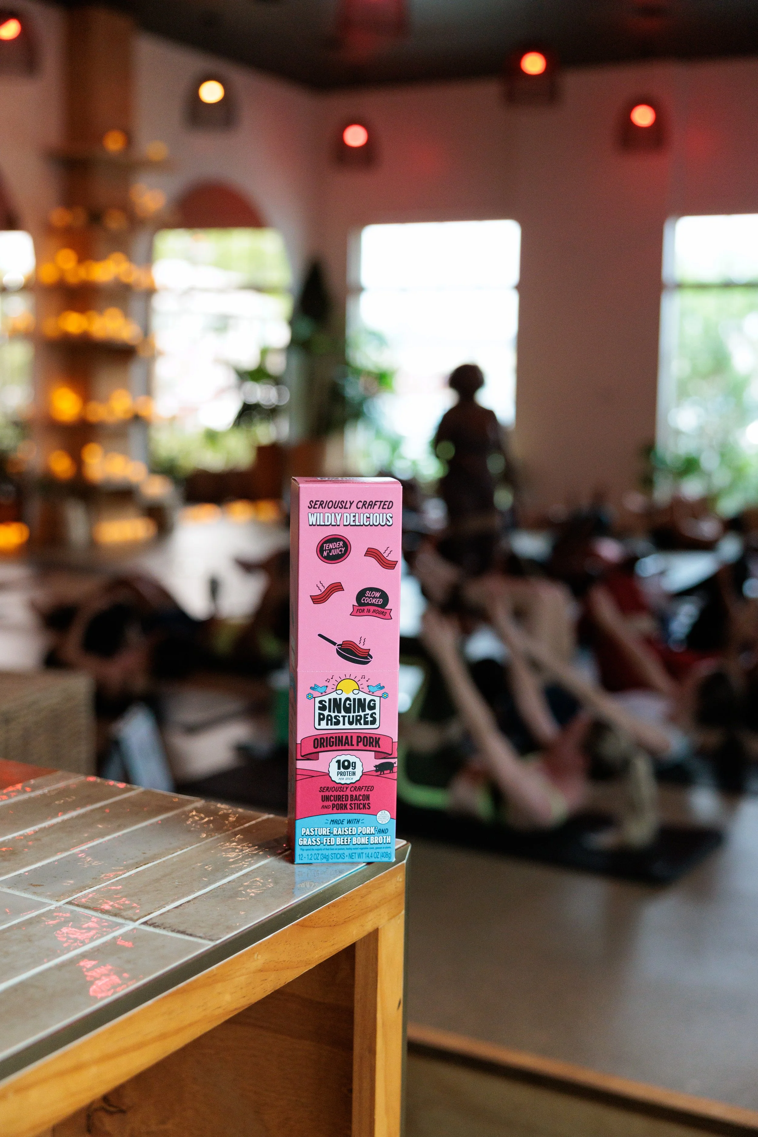 A box of Singing Pastures meat sticks showcased at a wellness experiential marketing event. 