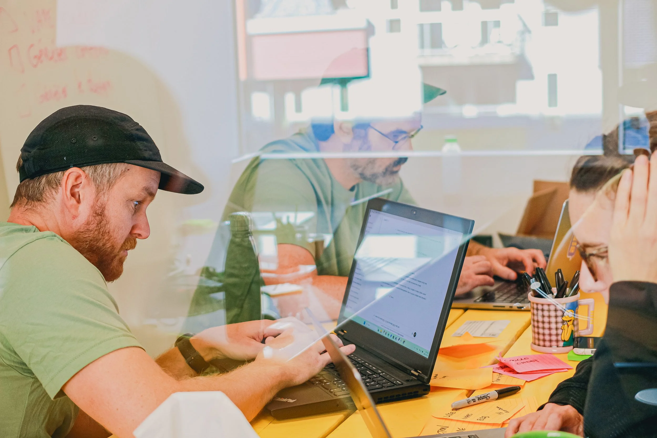 Une équipe qui travaille dans une salle avec leurs ordinateurs