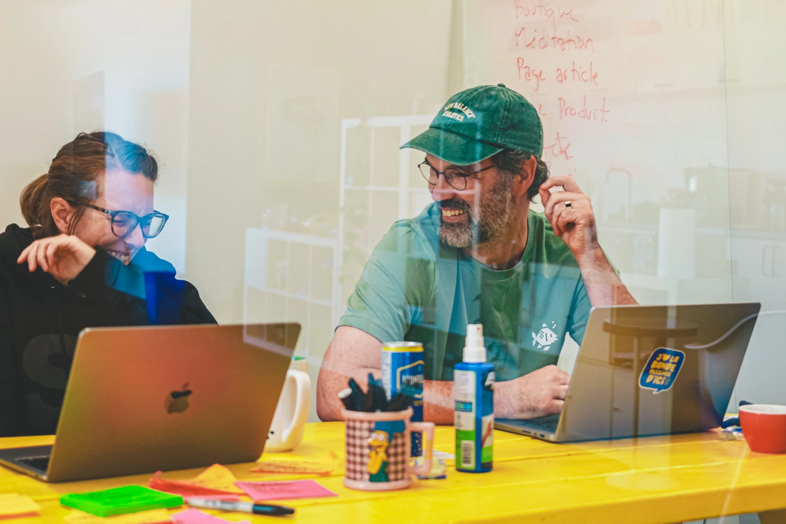 Des personnes souriantes en atelier avec leurs ordinateurs