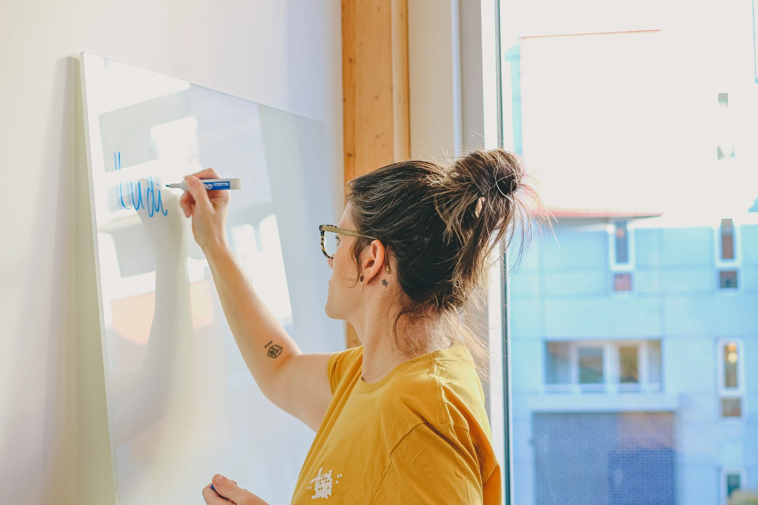 Mylène écrit sur un tableau lors d'un atelier