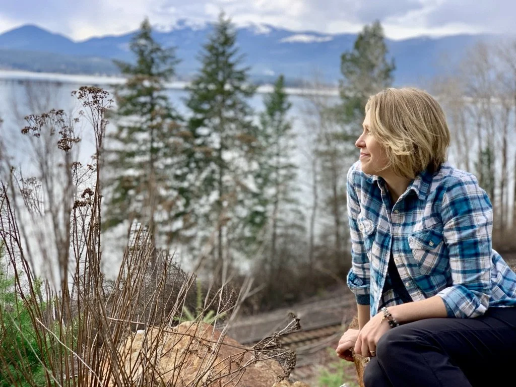 Chantal looking out over the mountains, lake and a train track.