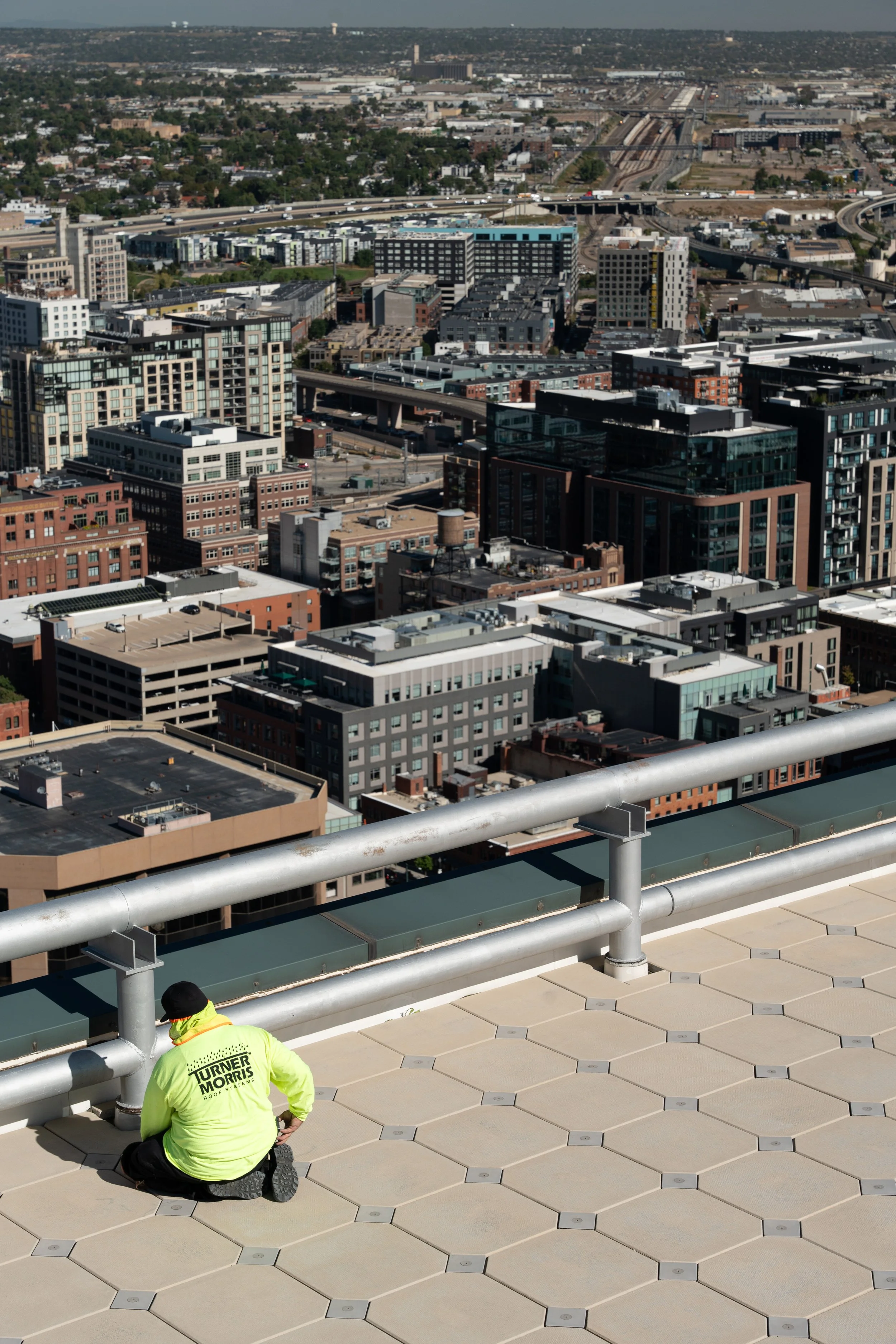 Worker on rooftop overlooking cityscape