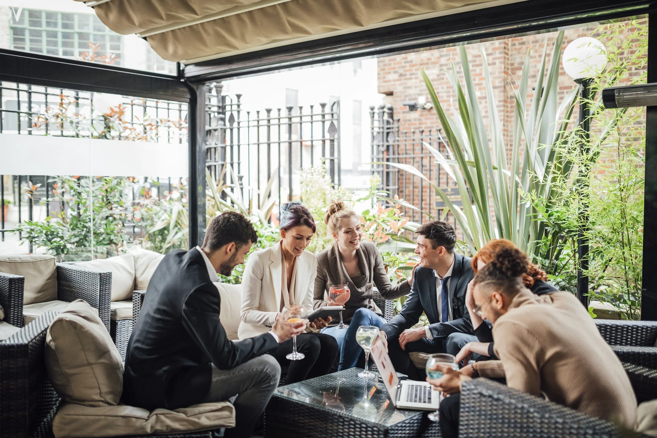Group of coworkers in suits having a drink for happy hour.