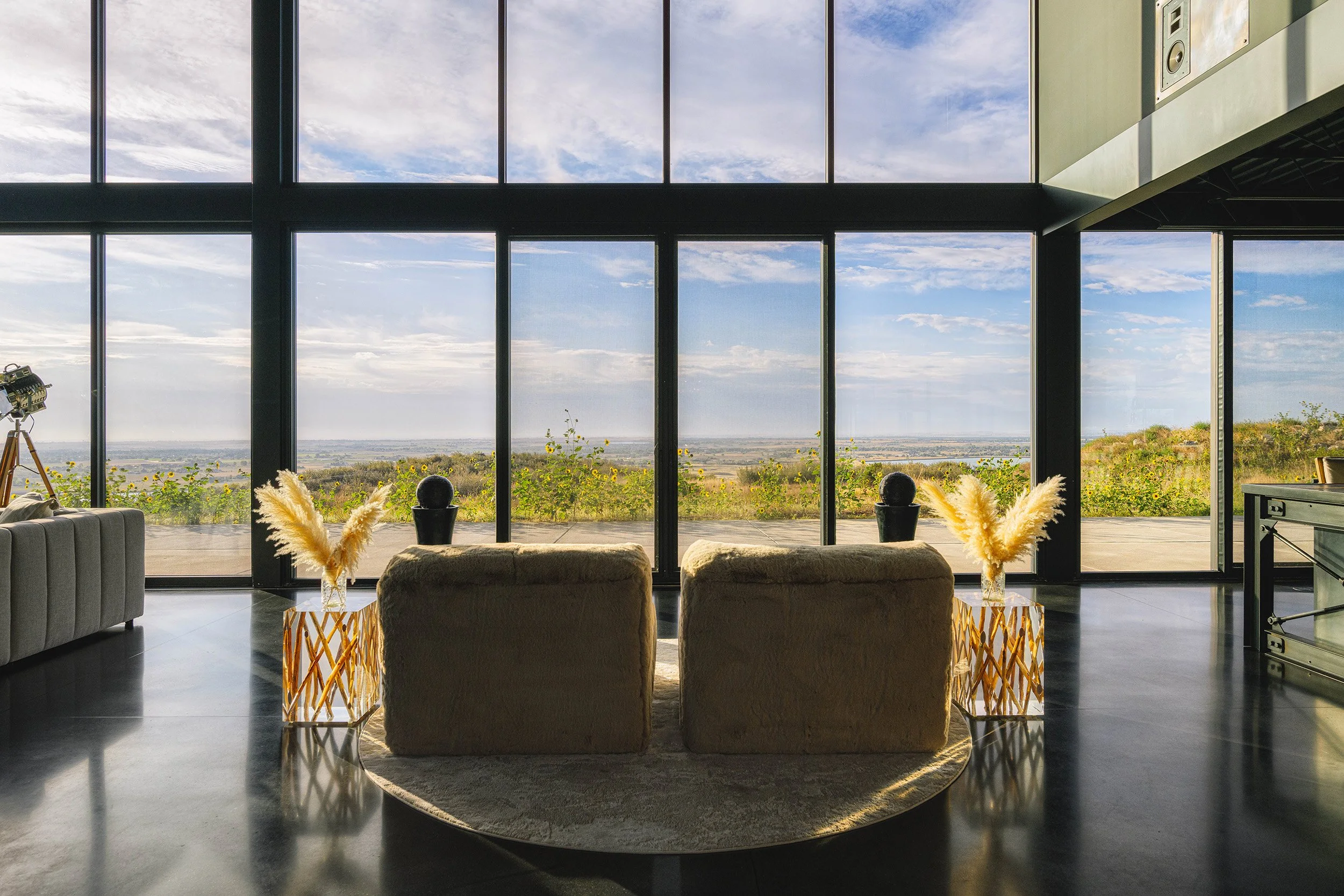 aggregate-steel-living-room-floor-to-ceiling-windows-cream-chairs.jpg