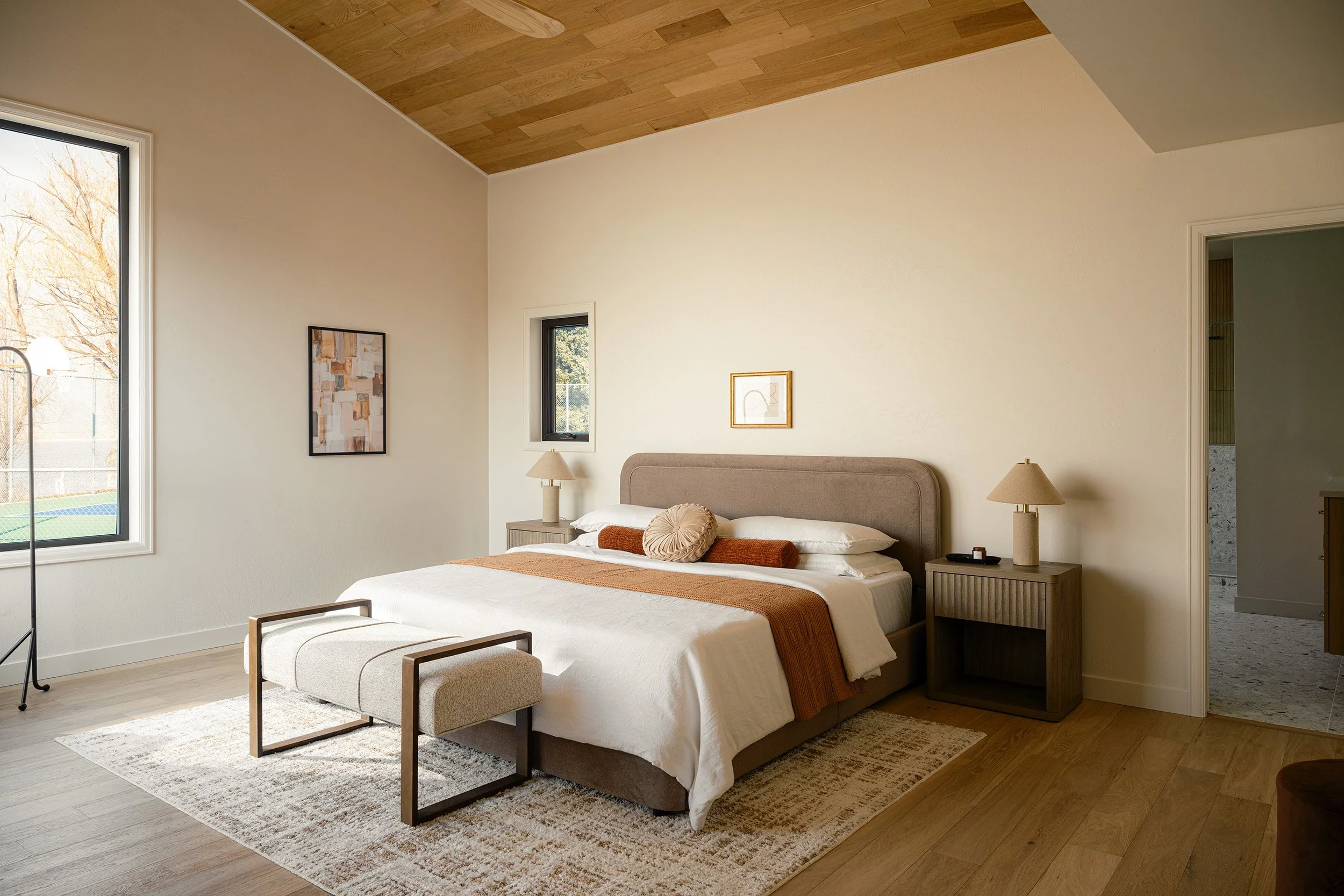 terrazzo-timber-primary-bedroom-rust-orange-throw-warm-wood-ceiling.jpg