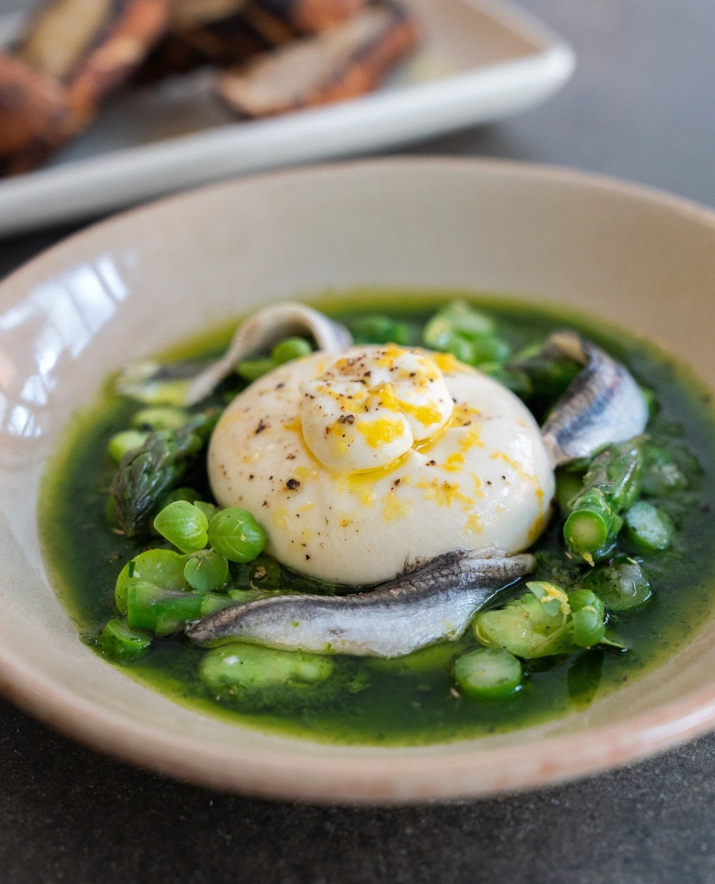 Nothing says summer quite like a fresh burrata 🌱⁠
⁠
Served with salsa verde, asparagus, broad beans &amp; white anchovies.⁠
⁠
#OsteriaOggi #Burrata #SalsaVerde #Anchovy #Summer #Menu #Antipasto
