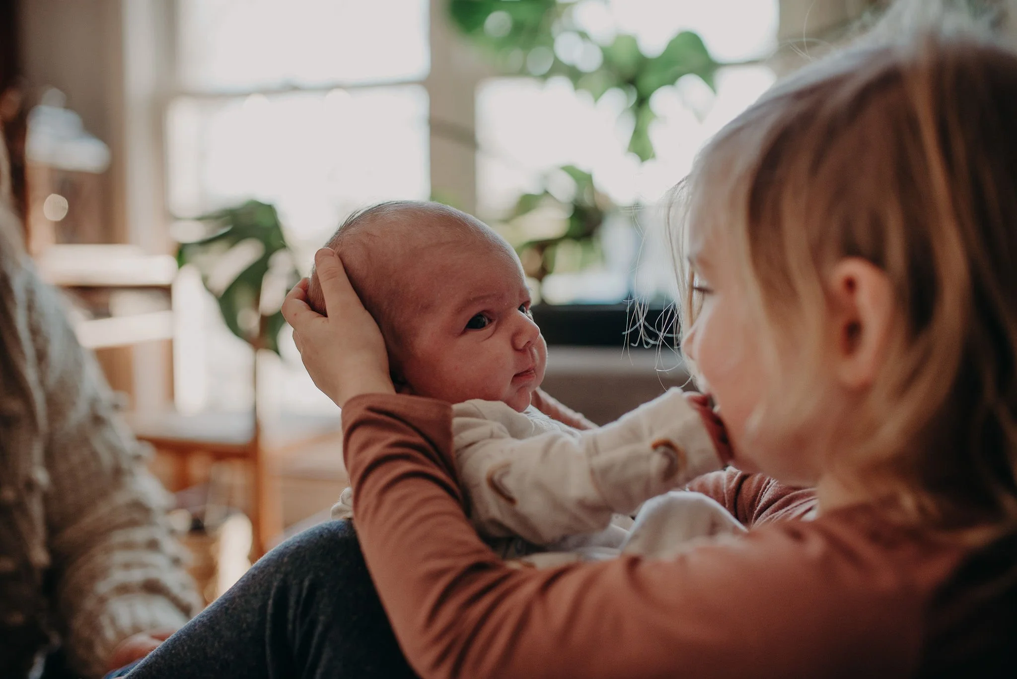 Newborn baby and sibling with the support of a postpartum doula.