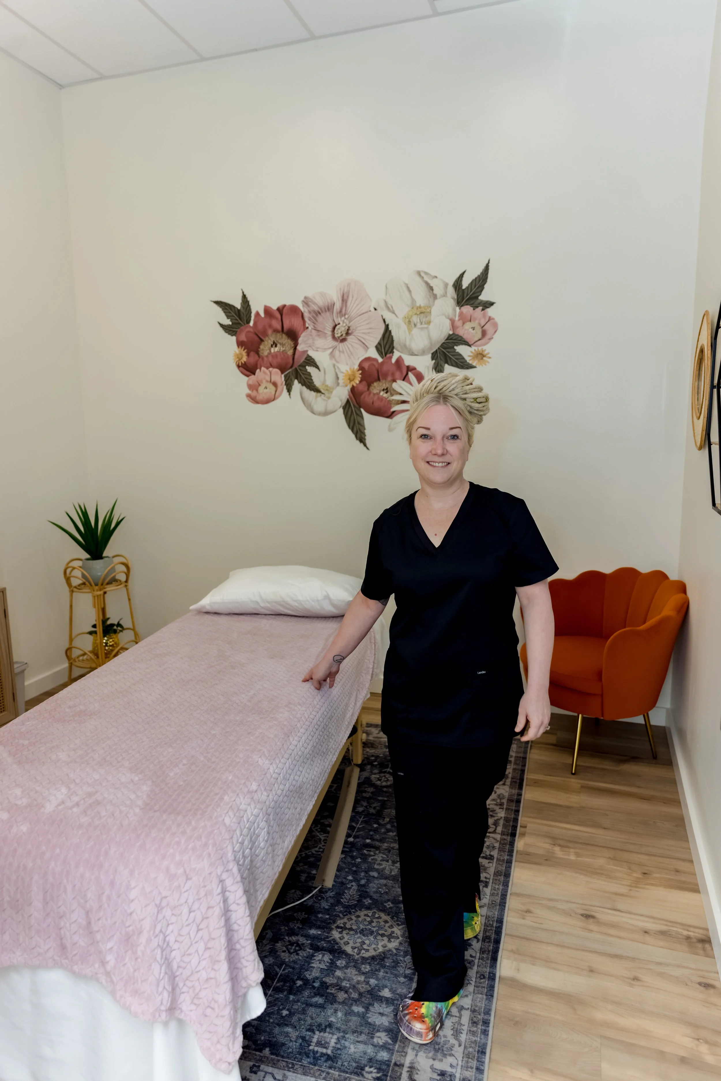 Massage therapist standing next to a massage table