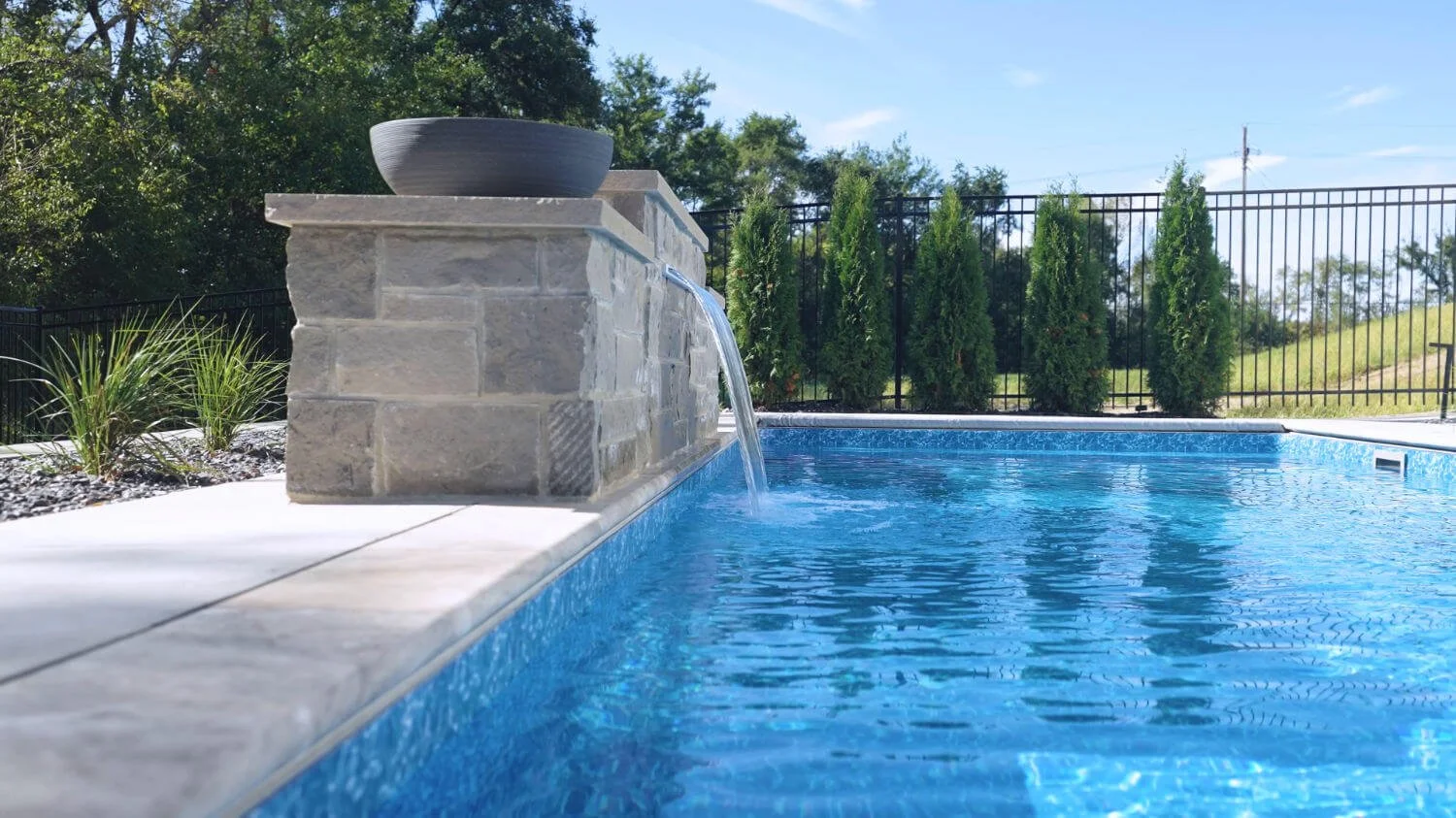 custom pool with waterfall feature in Omaha, NE designed for comfortable poolside living and family gatherings 