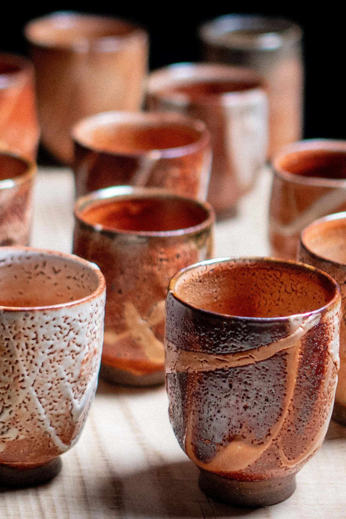 Handmade yunomi cups with Shino glaze featuring crackled textures and soft atmospheric surfaces.