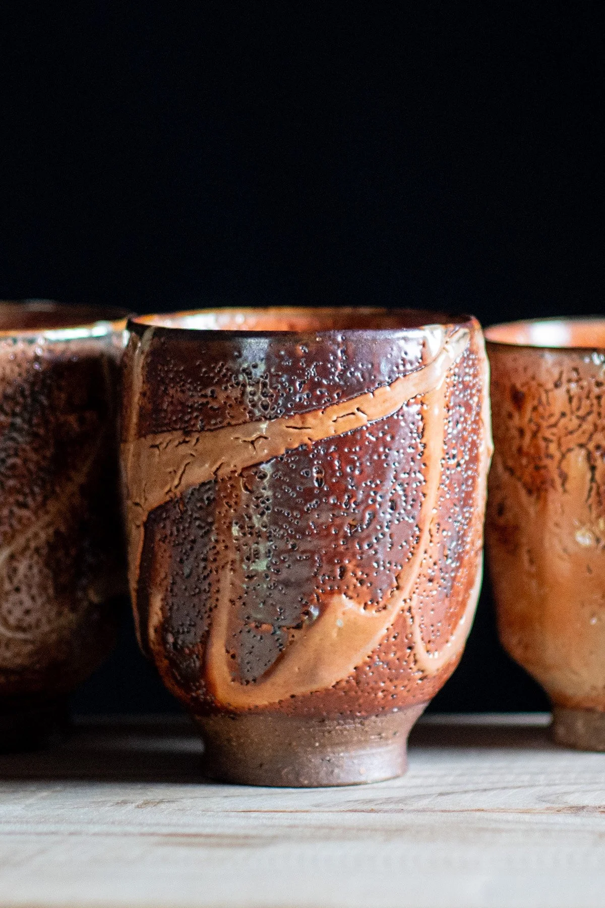Handmade yunomi cups with Shino glaze featuring crackled textures and soft atmospheric surfaces.