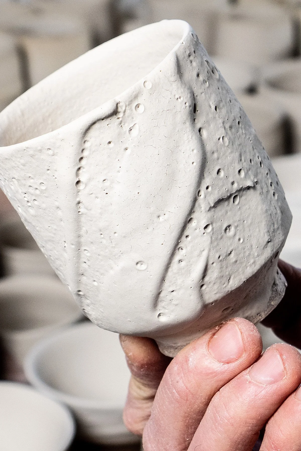 Applying Shino glaze by hand before firing in a soda and reduction atmosphere kiln.