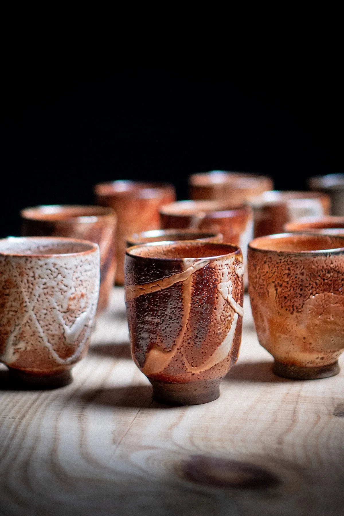 Handmade yunomi cups with Shino glaze featuring crackled textures and soft atmospheric surfaces.
