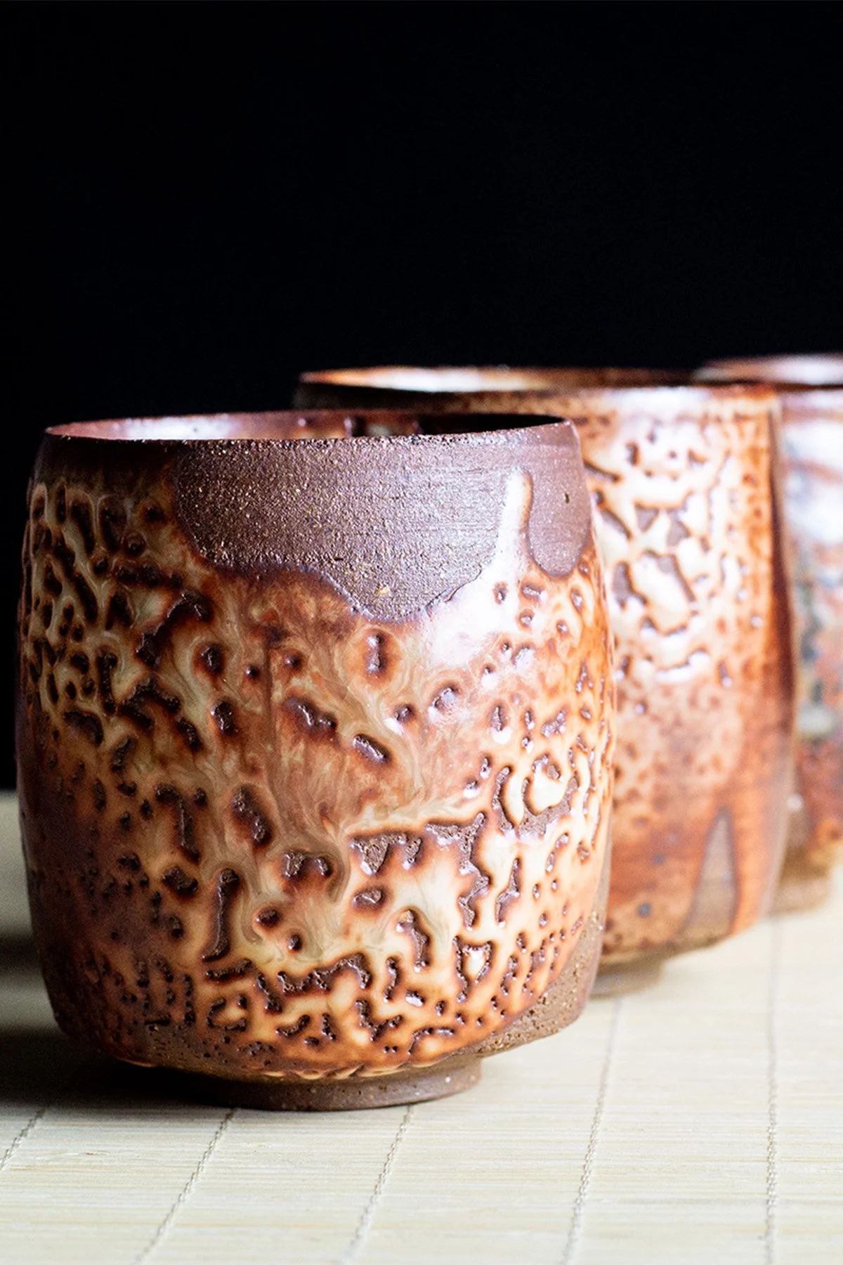 Handmade yunomi cups with Shino glaze featuring crackled textures and soft atmospheric surfaces.