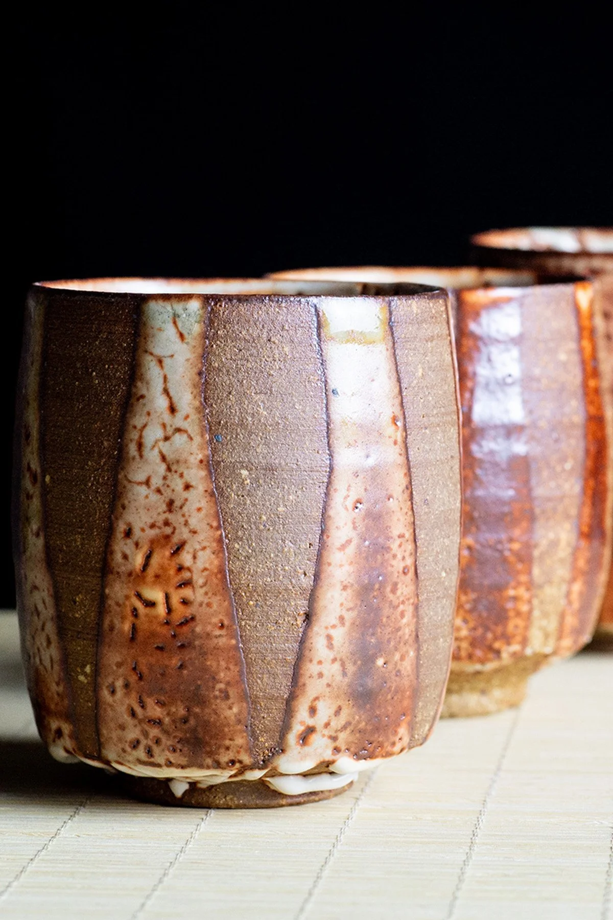 Handmade yunomi cups with Shino glaze featuring crackled textures and soft atmospheric surfaces.