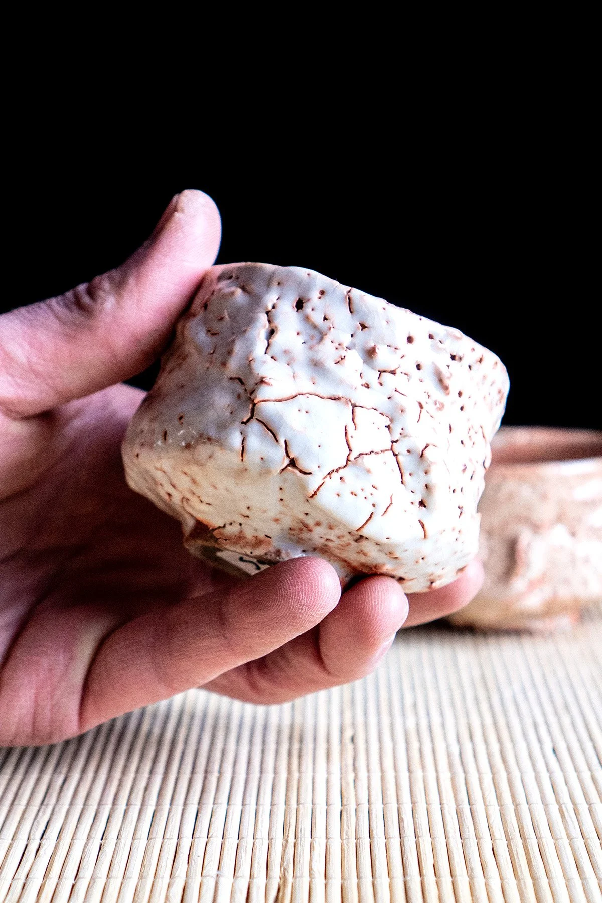 Small handmade sake cups with expressive Shino glaze surfaces shaped by fire and reduction firing.